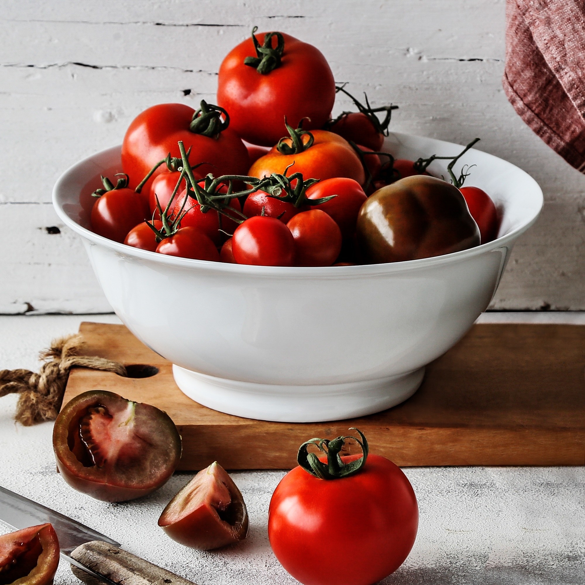 A large white bowl full of tomatoes