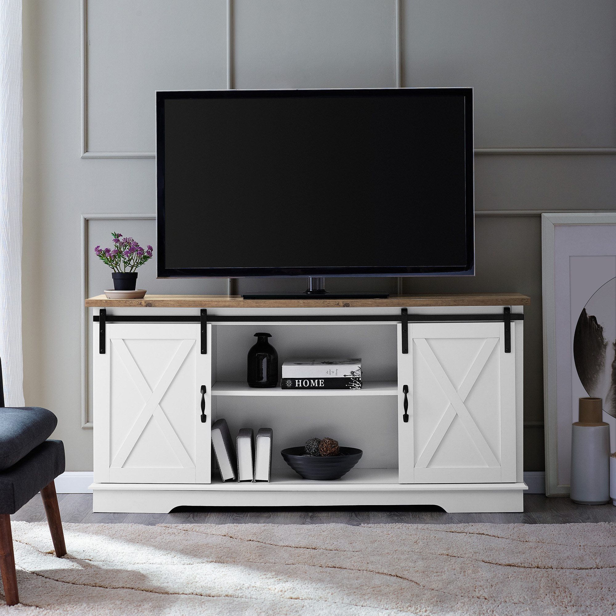 The TV stand, which has two open storage shelves in the center, and one closed cabinet shelf with handle on either side