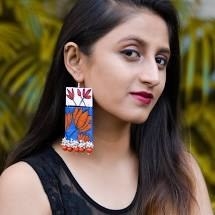 A model wears a long fabric earring