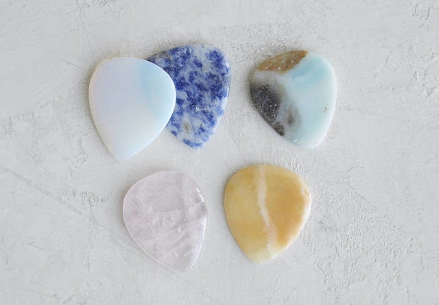 Five guitar picks in different gem stones