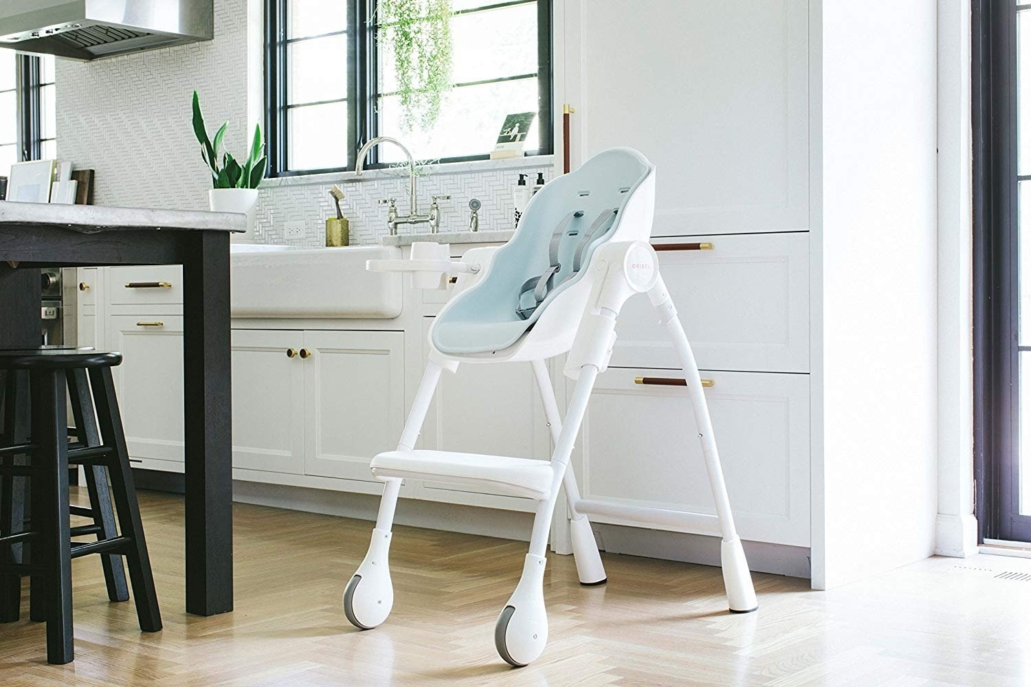 White and light blue high chair with two gray wheels