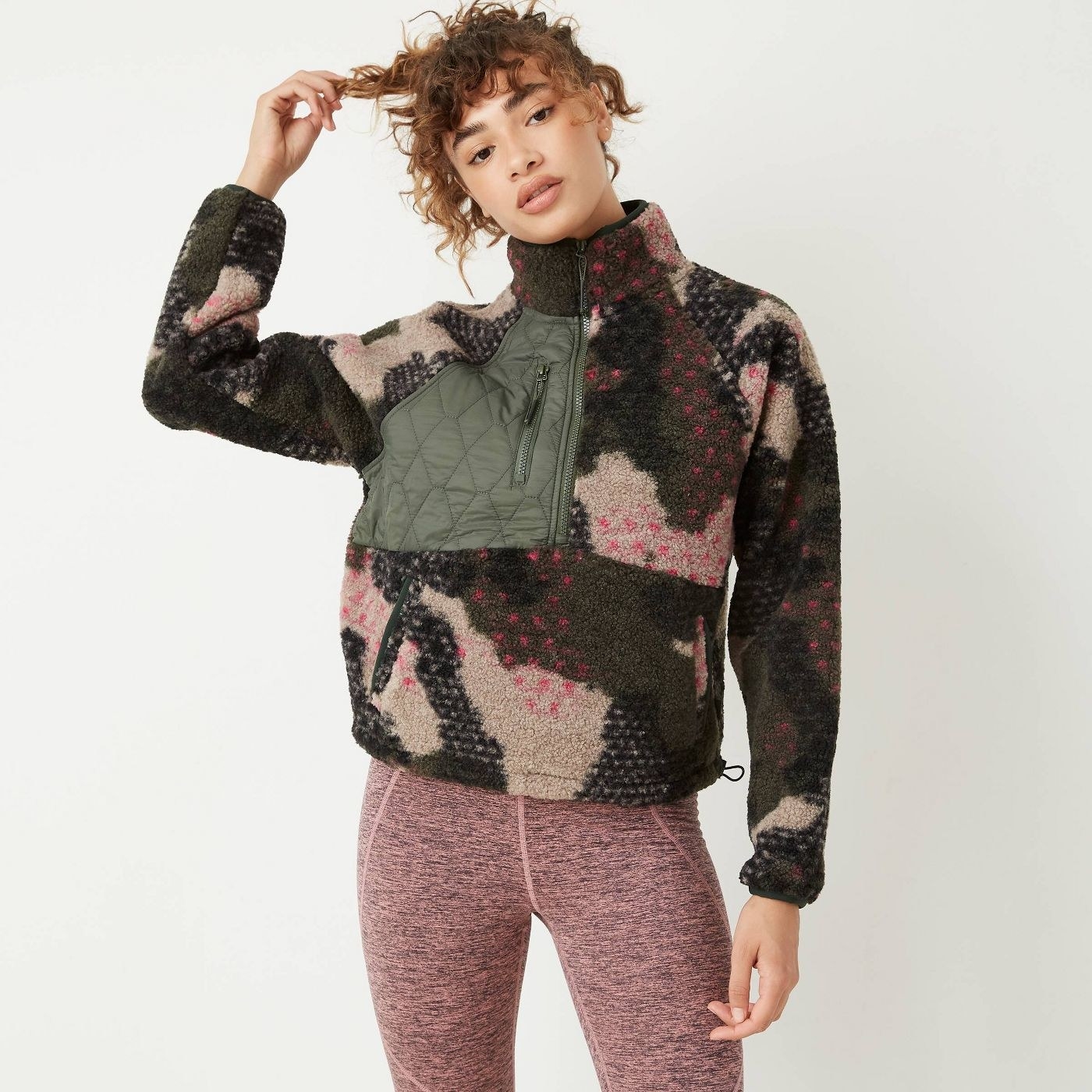 Model in camo zip fleece sweatshirt with pink leggings 