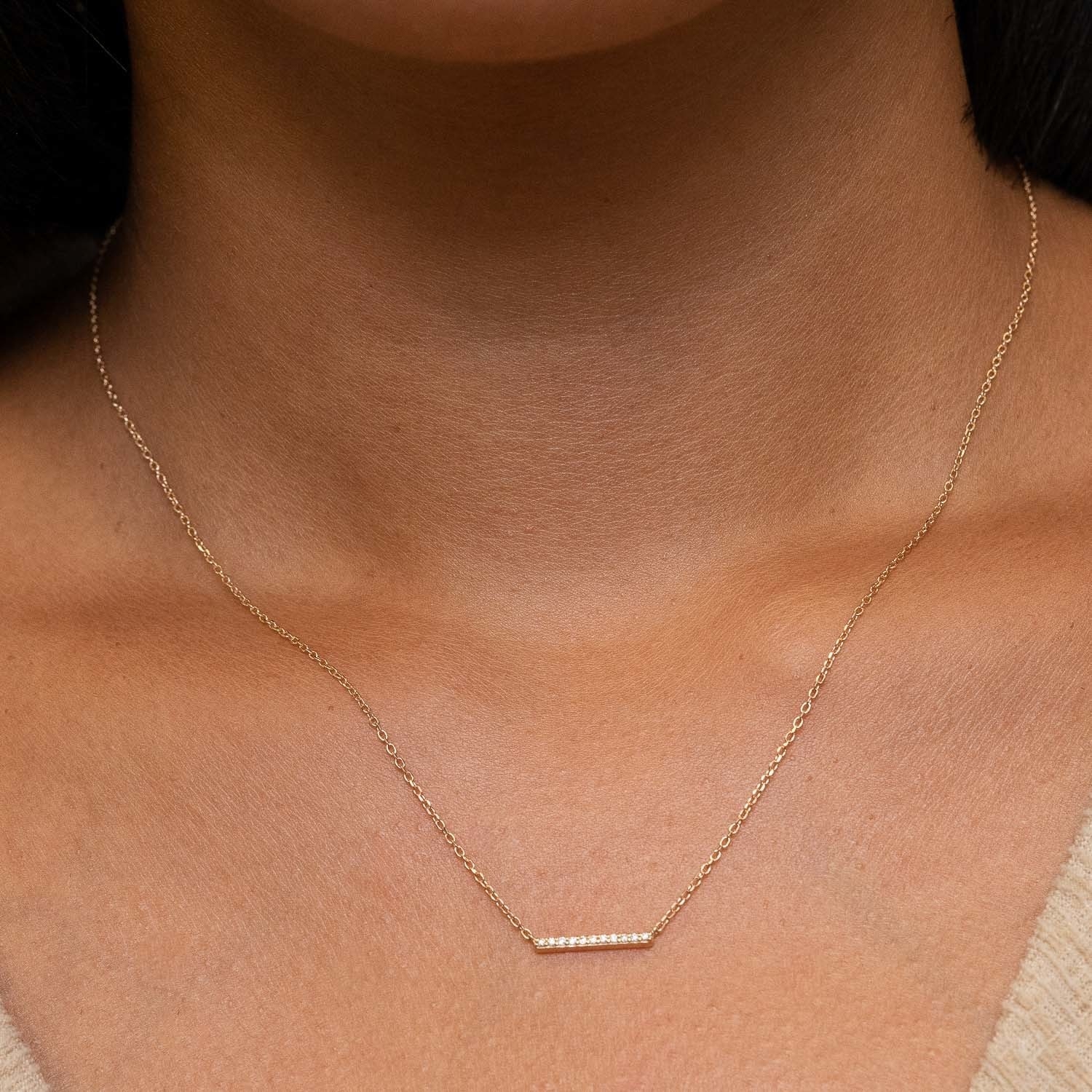 A model wearing the yellow gold necklace with tiny diamonds
