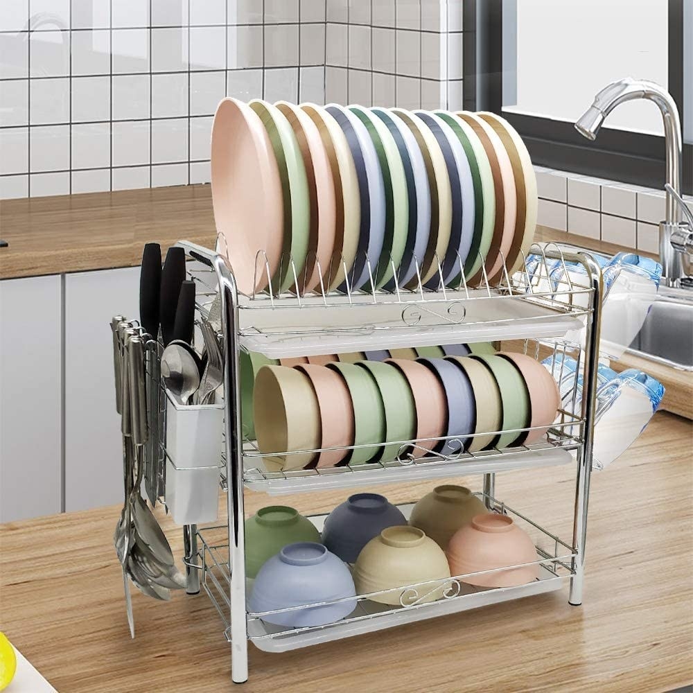 A fully-loaded dish rack on a wooden kitchen counter