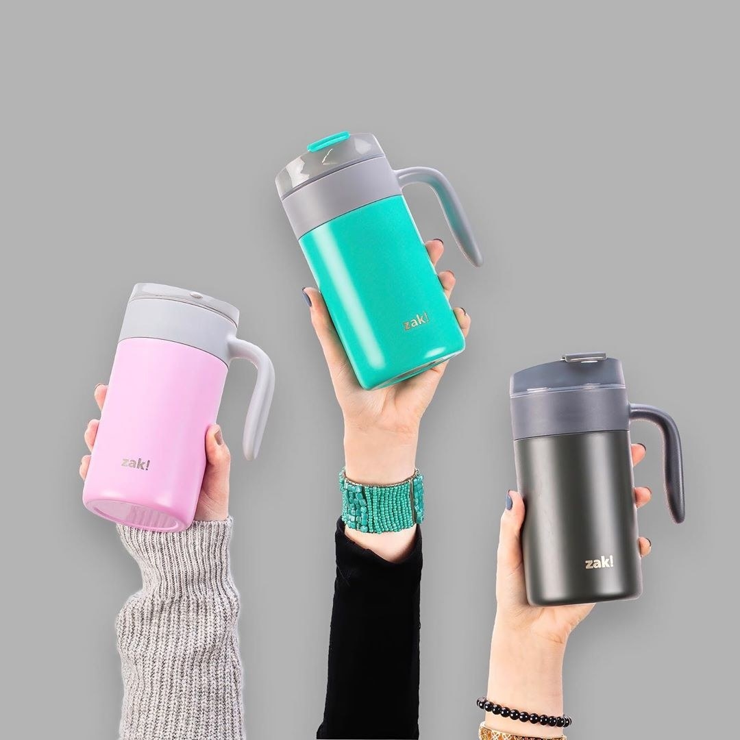 People holding the mugs in pink, teal, and gray