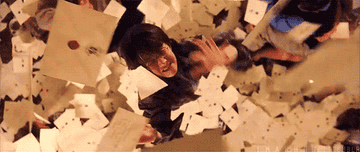 Harry Potter getting pelted by hundreds of letters from Hogwarts