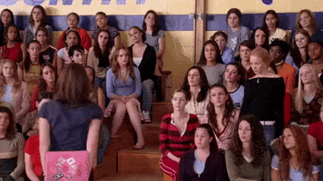A crowd of people from &quot;Mean Girls&quot; raising their hands