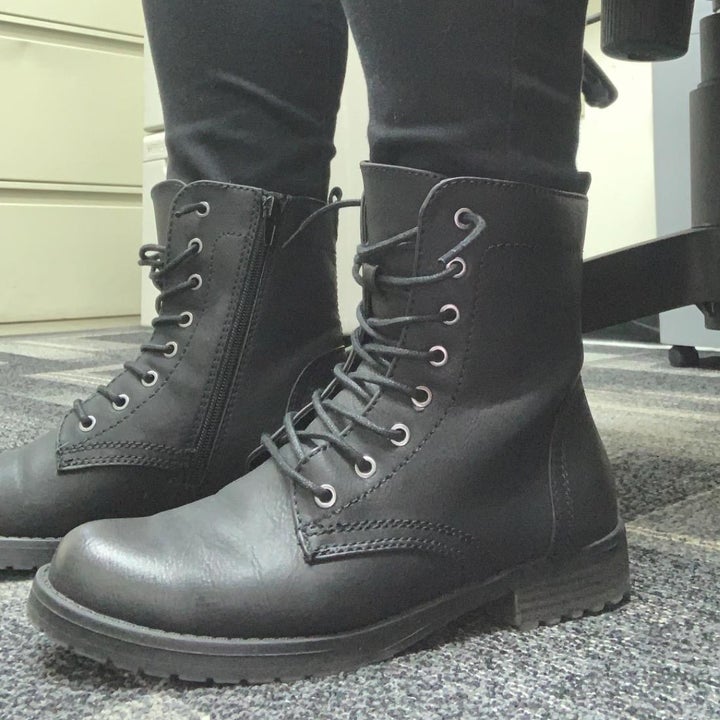 reviewer wearing the black boots with laces and a side zipper 
