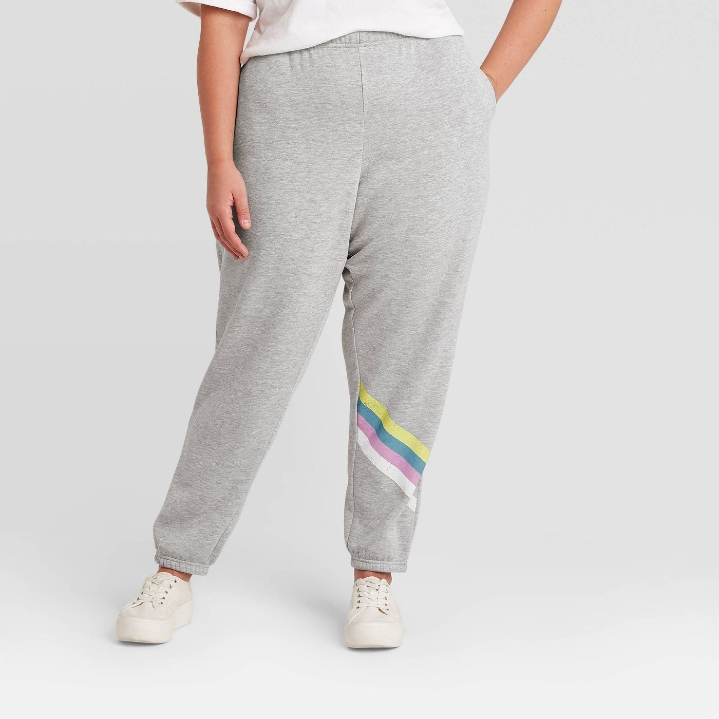 Model in gray joggers with colorful stripes on the leg