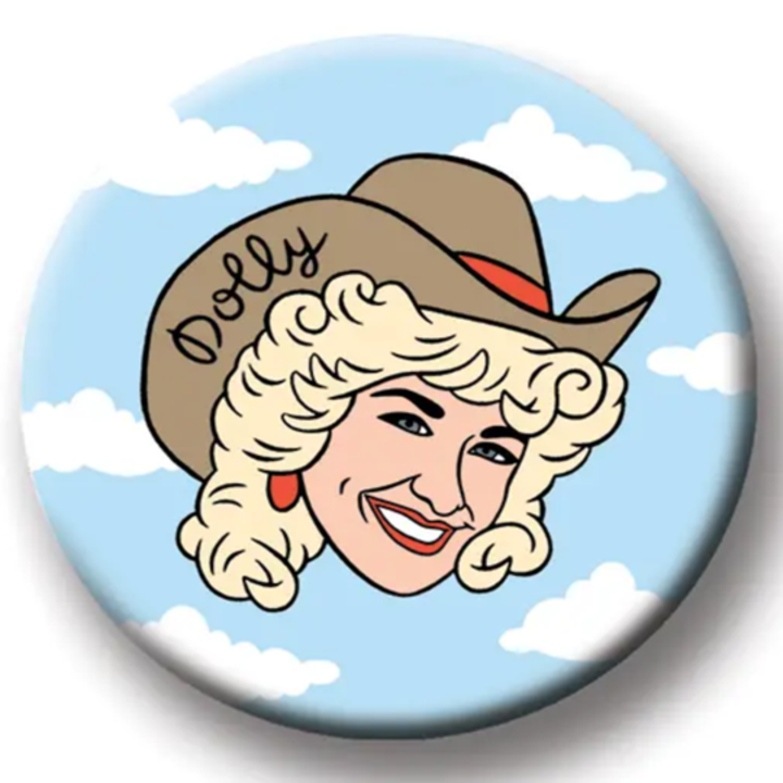 Illustrated round Dolly magnet with her face and name against a blue sky with clouds