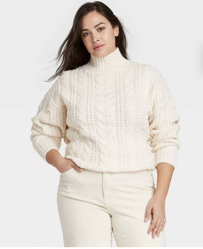 model wearing white cable knit sweater