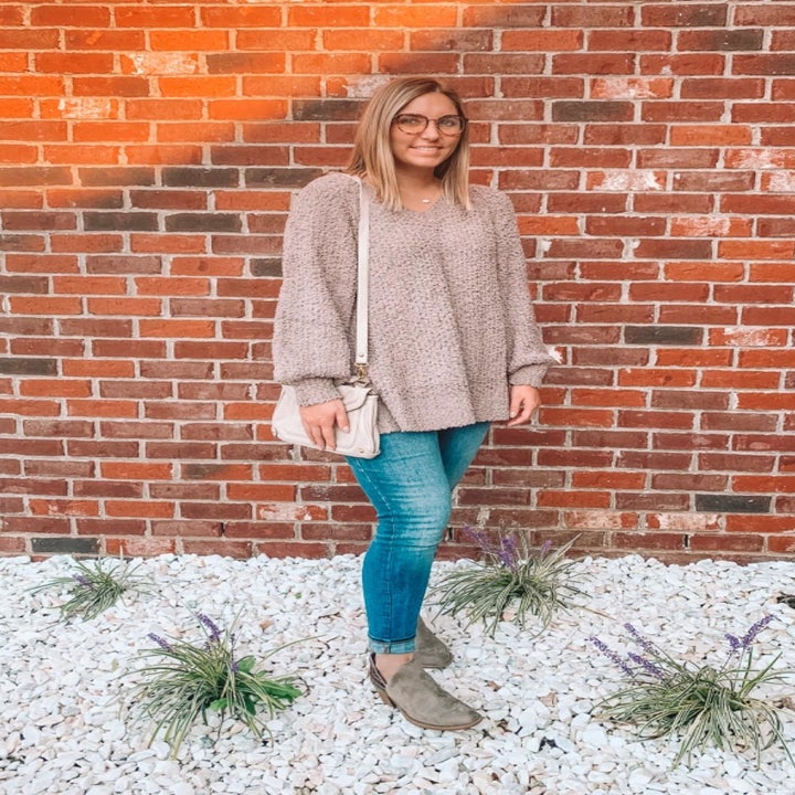 reviewer wearing the sweater in taupe with jeans and booties 