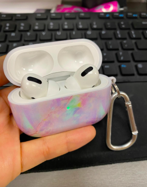 hand holding airpods case in marble print