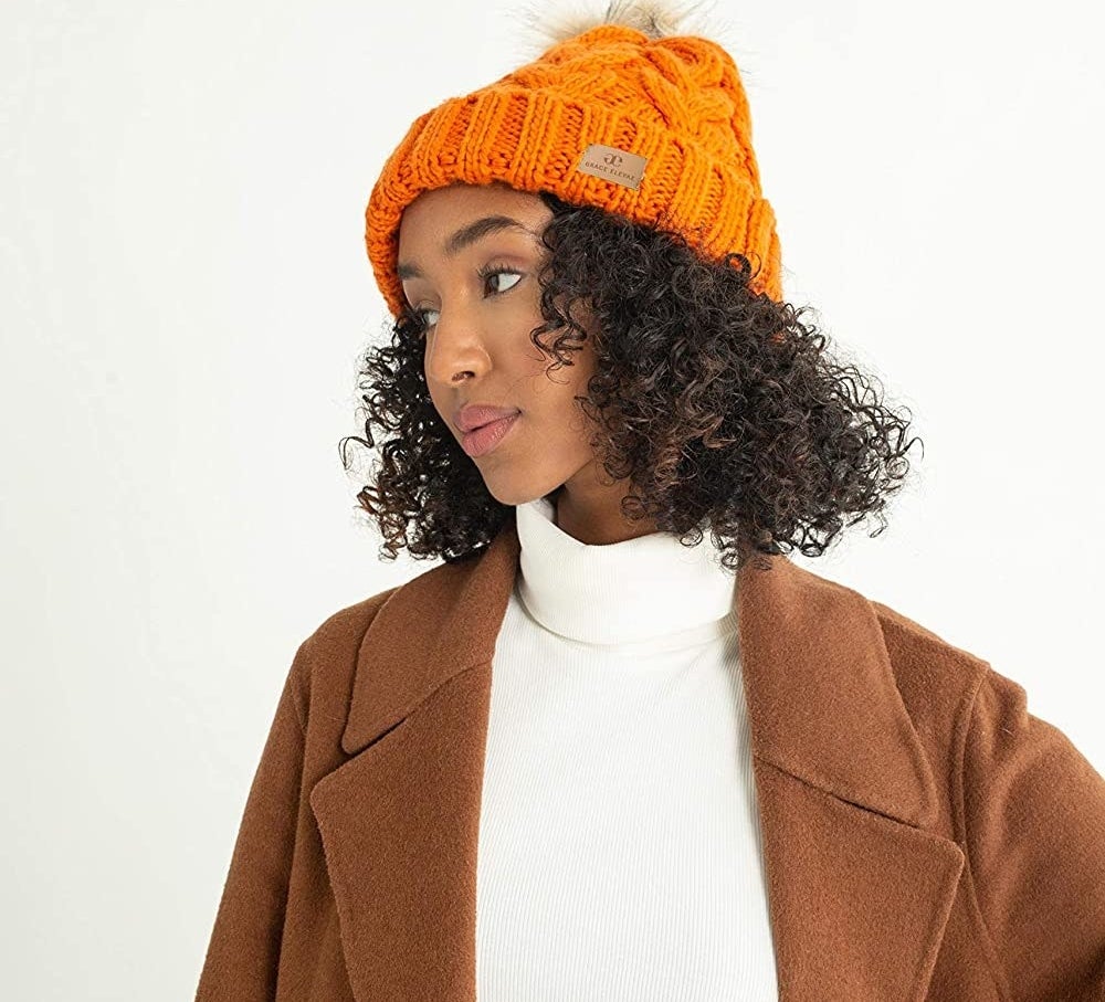 Model in the orange hat with a faux fur pompom
