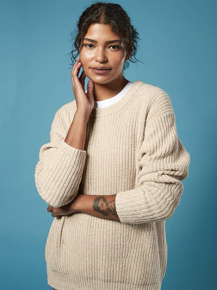 Model wearing the sweater in an oatmeal color