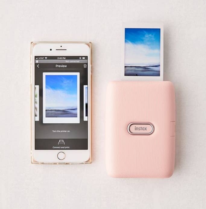 Fujifilm mini link smartphone printer in pink next to an iPhone