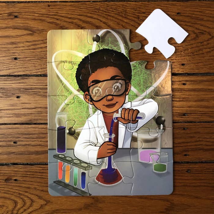 the puzzle put  together with a little boy pouring a concoction into a beaker. He&#x27;s wearing a white lab coat and protective goggles. one piece is missing from the puzzle and sitting right beside it.