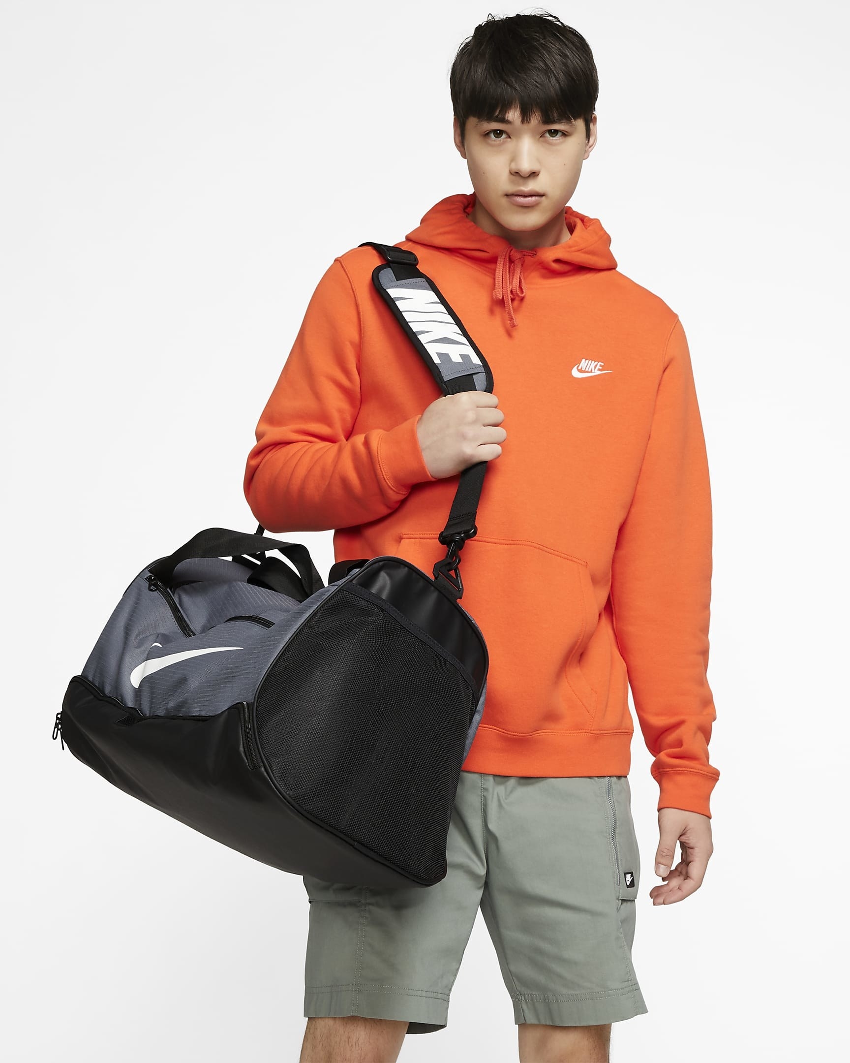 Model carrying black and grey duffle bag