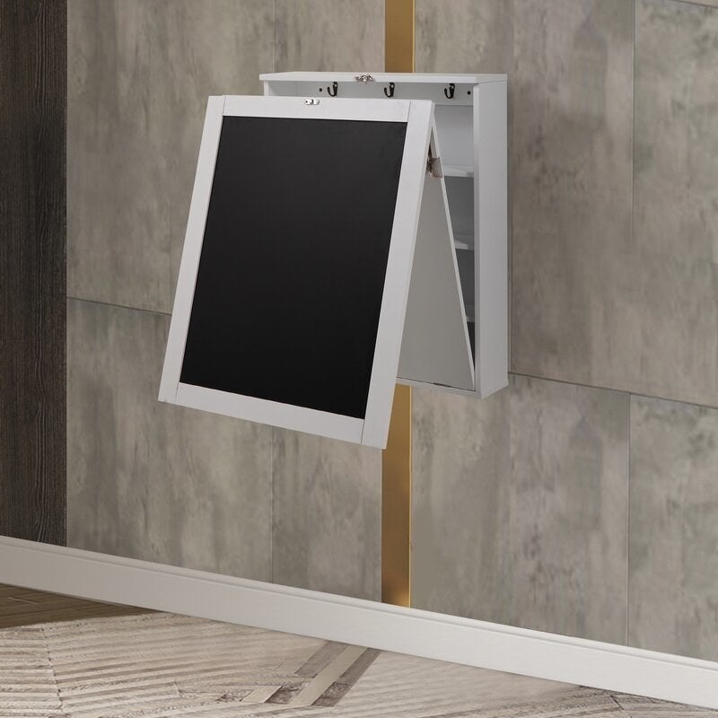 A white and black folding desk folded up against a wall