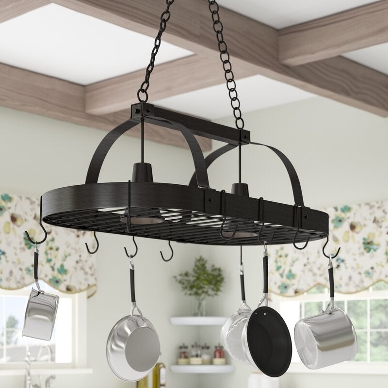 Pots and pans hanging on a black metal hanger in a kitchen