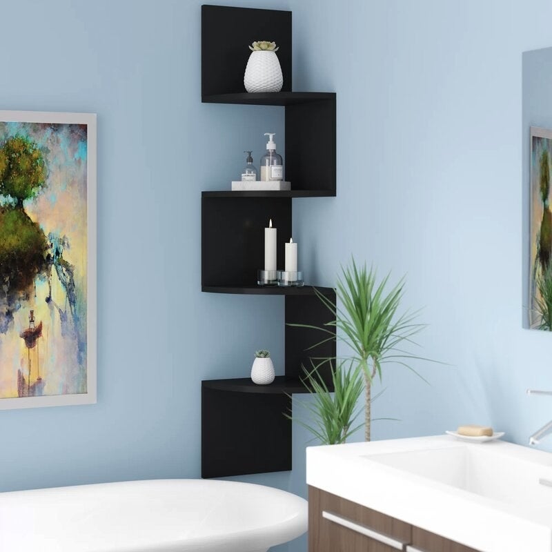 A bathroom with a black artistic bookshelf in. the corner next to a white tub