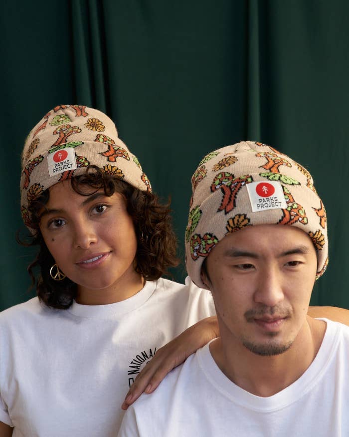 two models wearing the beanie with a Parks Project logo on the front