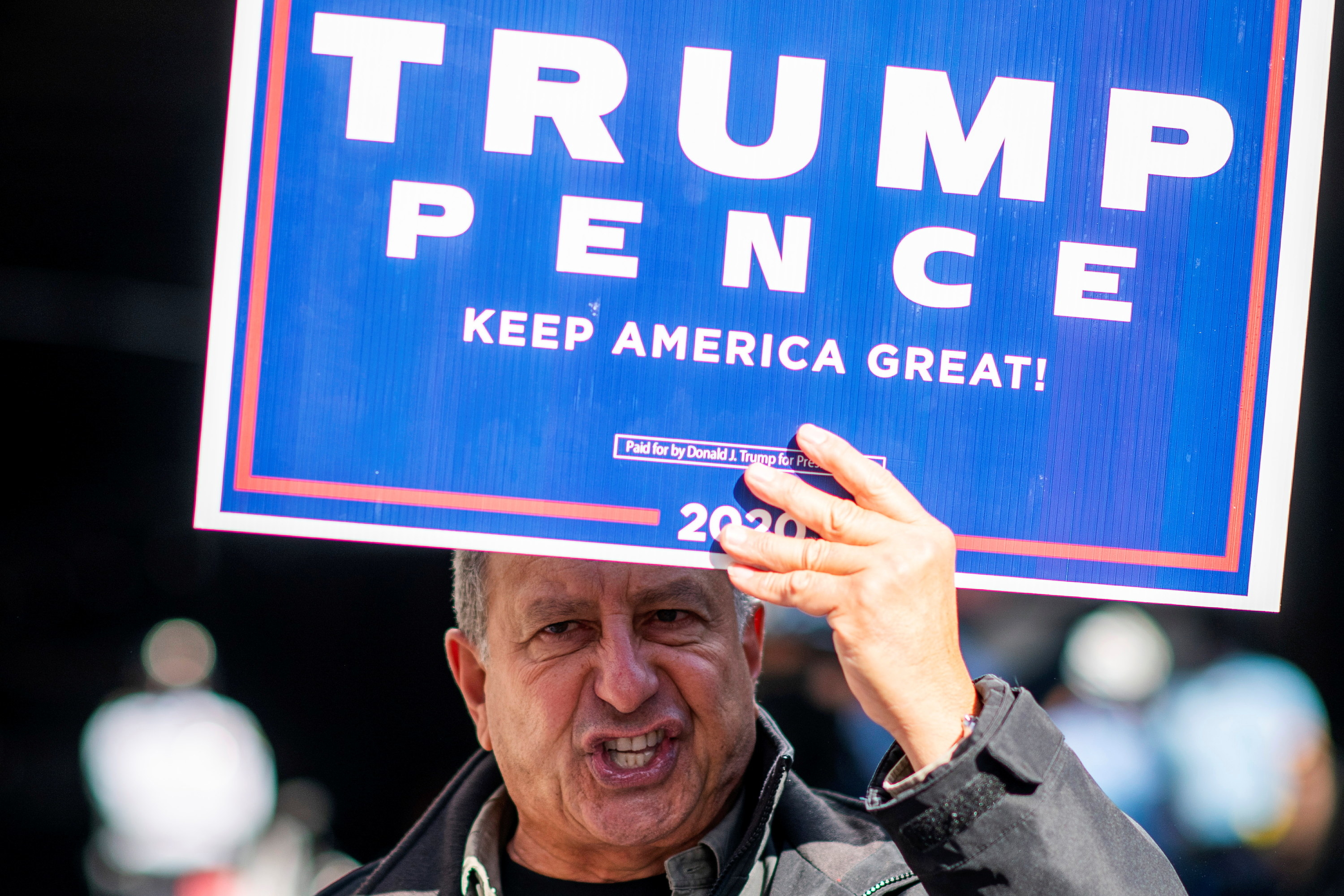 Man holds up sign that says &quot;TRUMP, Pence, Keep America Great!&quot;