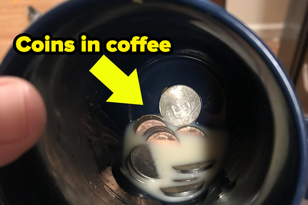 A coffee mug with coffee and coins at the bottom