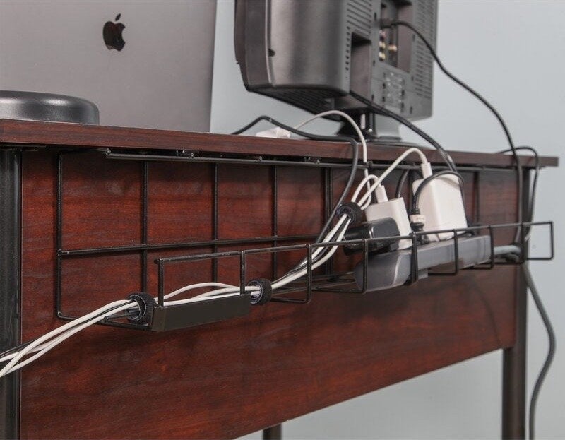 Black wire holders attached to the back of a desk