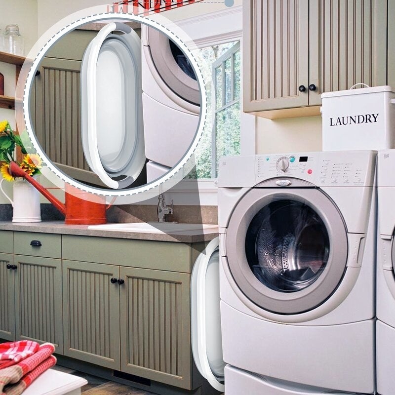 A laundry room with a washing machine, sink and laundry hamper