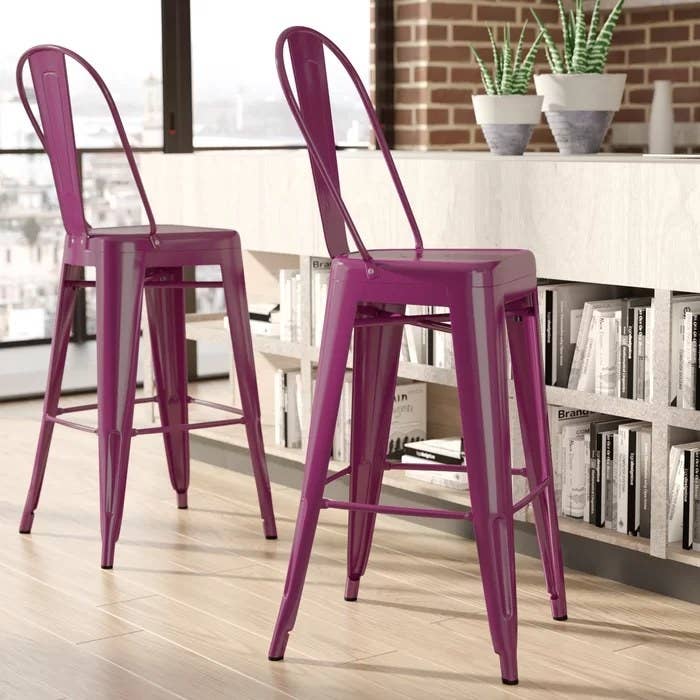 A close-up of two purple bar stools