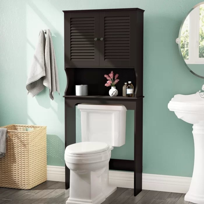 A black cabinet standing over the toilet 