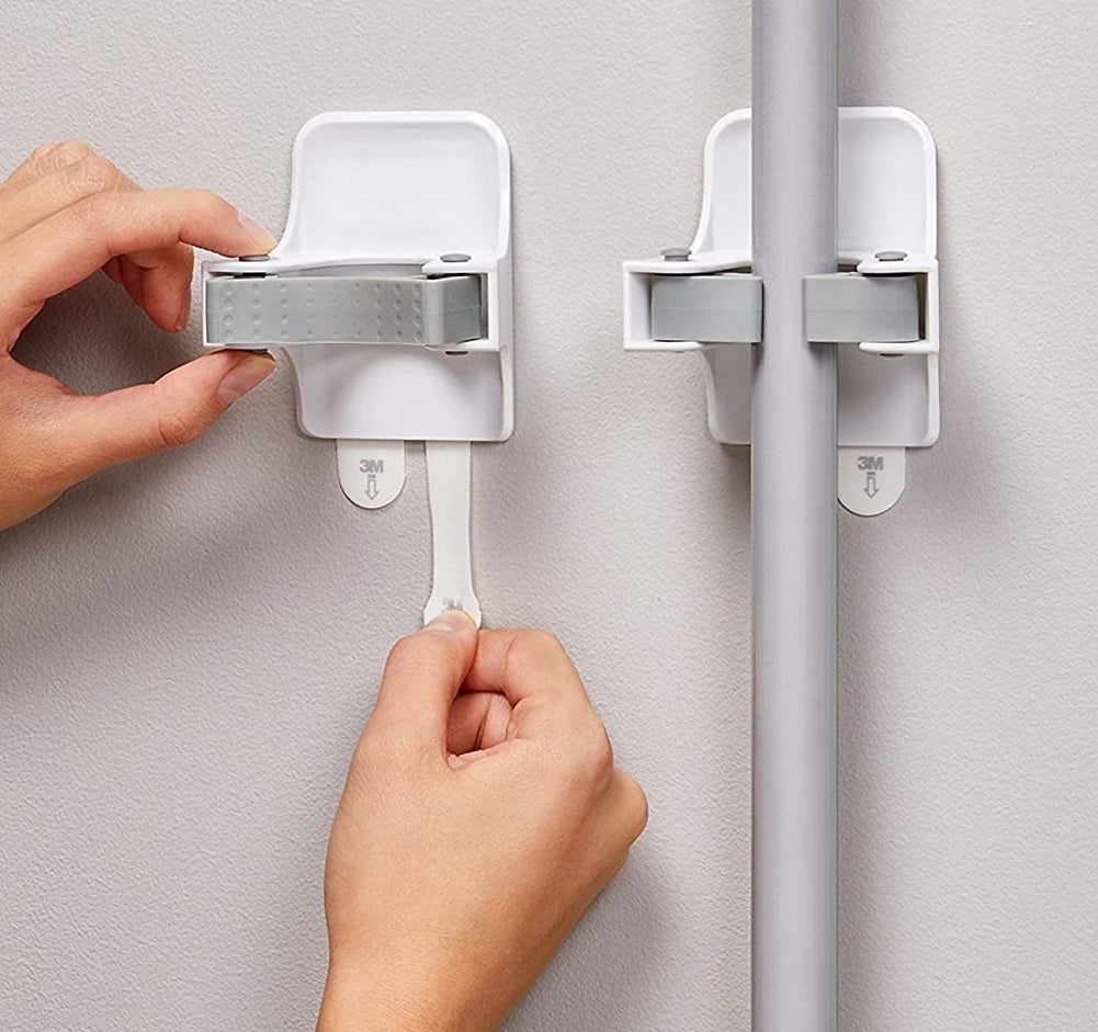 A person hanging the mount hooks on a wall
