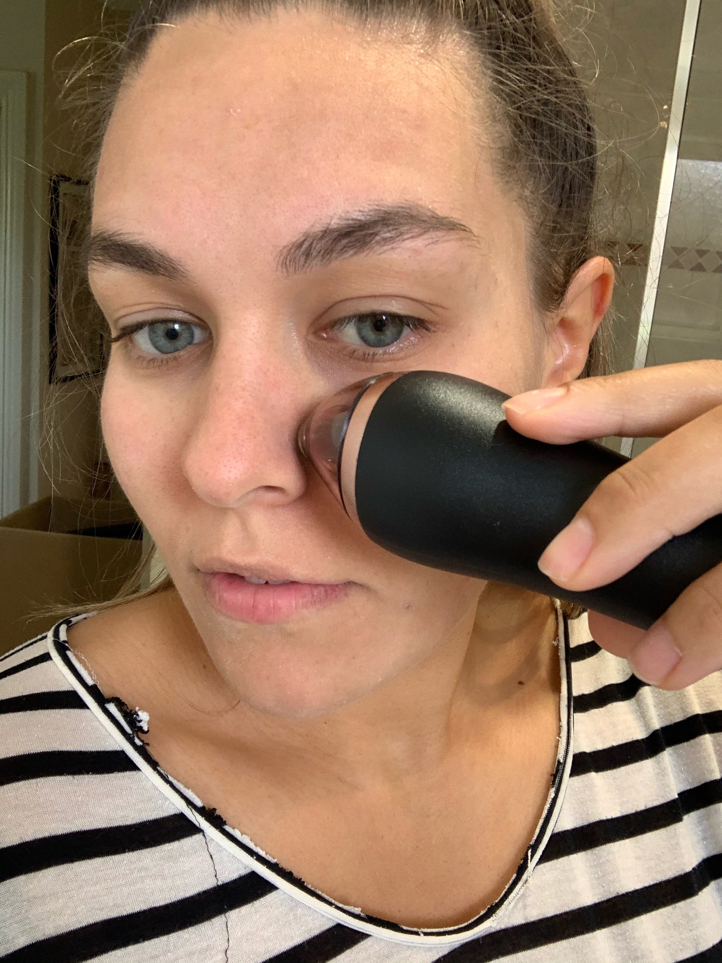 Writer using the Lumae Skin Microdermabrasion handset on her face