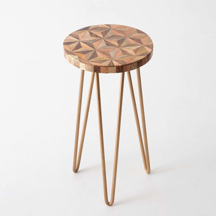 The hairpin-legged accent table with a wooden tabletop that has a geometric design in different shades of brown.
