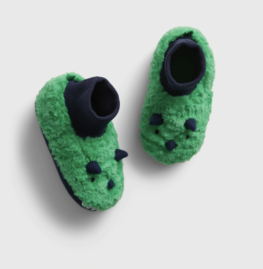 Product shot of green fuzzy baby dinosaur slippers
