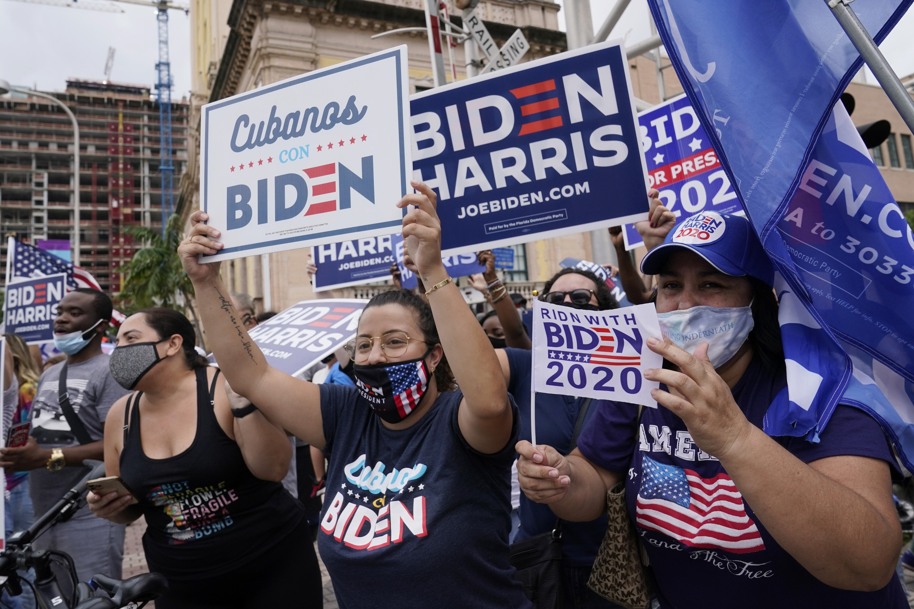 Someone holds up a sign that says &quot;Cubanos con Biden&quot;