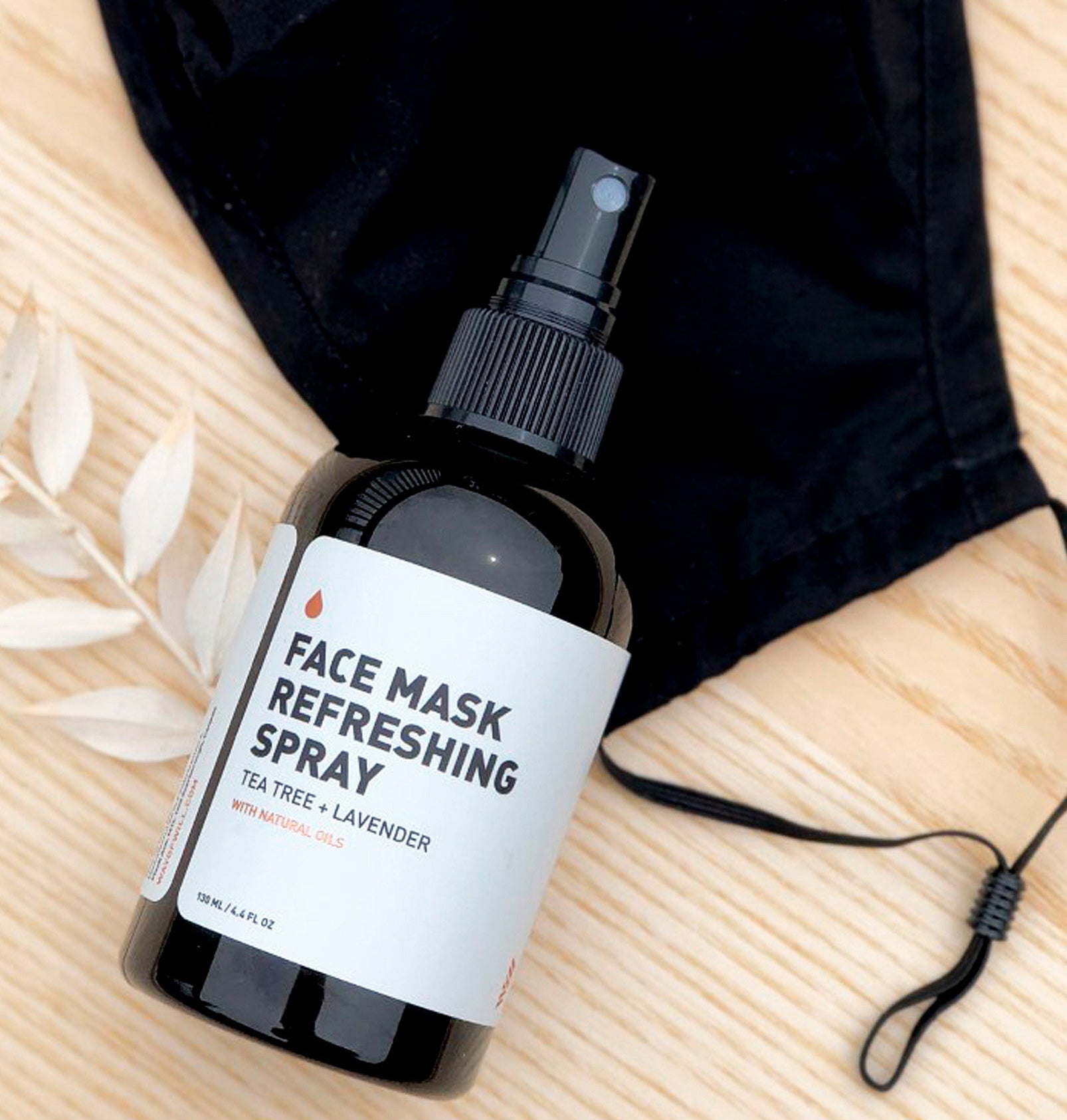 A bottle of face mask refreshing spray on top of a mask