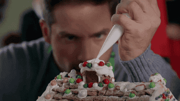 Christmas baking competitor adds final touches to his bake.