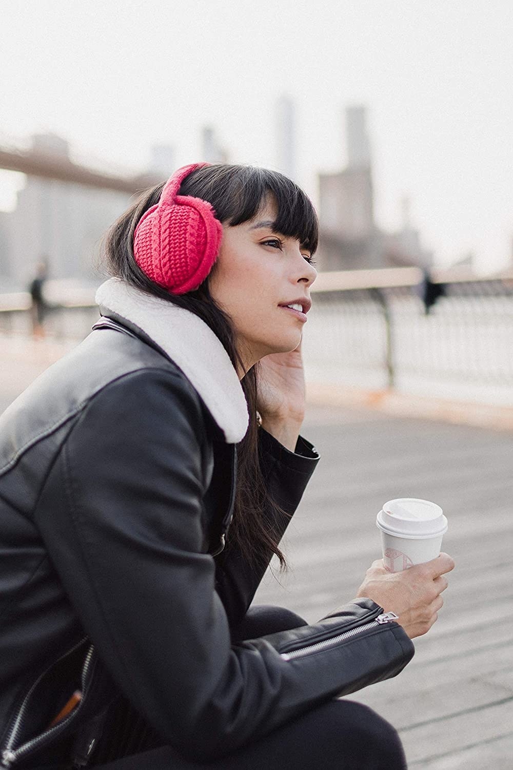 A model in the read headphones with a knit exterior and fluffy interior