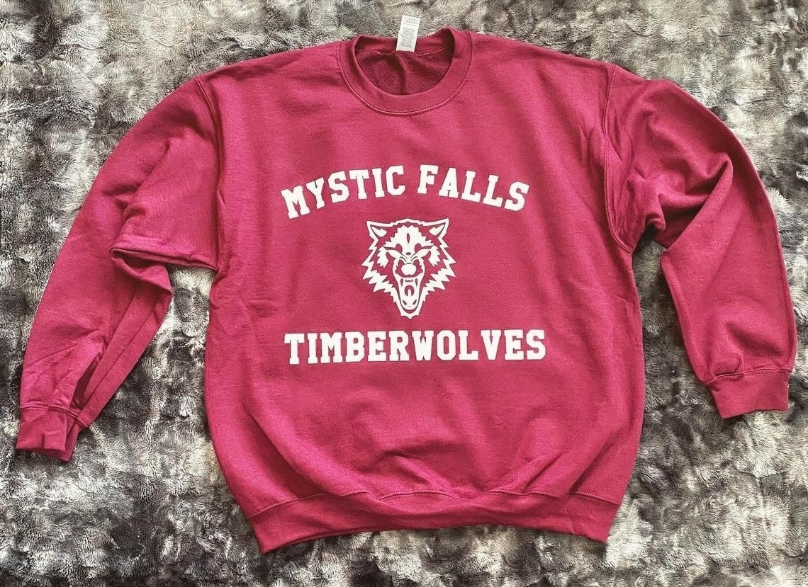 crewneck sweatshirt that says mystic falls timberwolves with a wolf in the center 