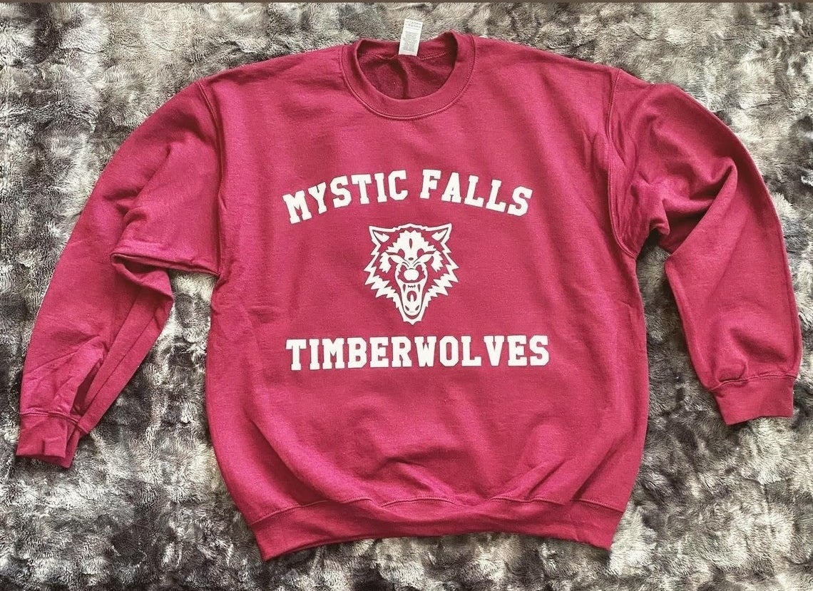 crewneck sweatshirt that says mystic falls timberwolves with a wolf in the center 