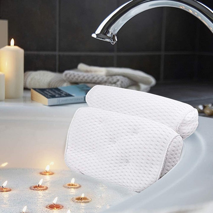 The bath pillow placed at the edge of a bathtub that's filled up with water