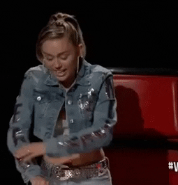 Miley Cyrus from The Voice rolling up her sleeves 