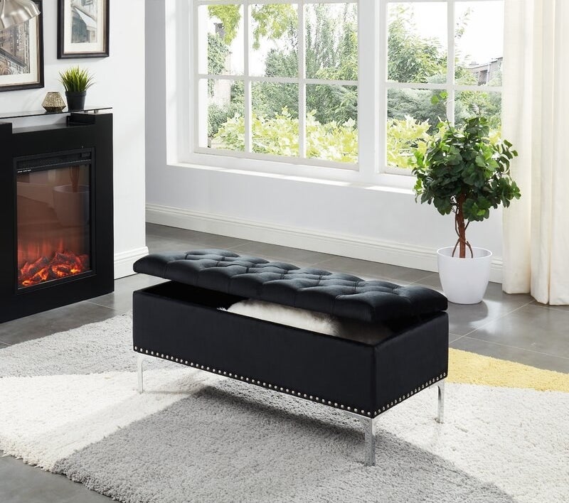 The black bench with metal studs on the bottom 