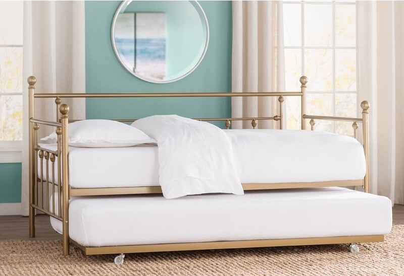 gold bed in room with metal frame