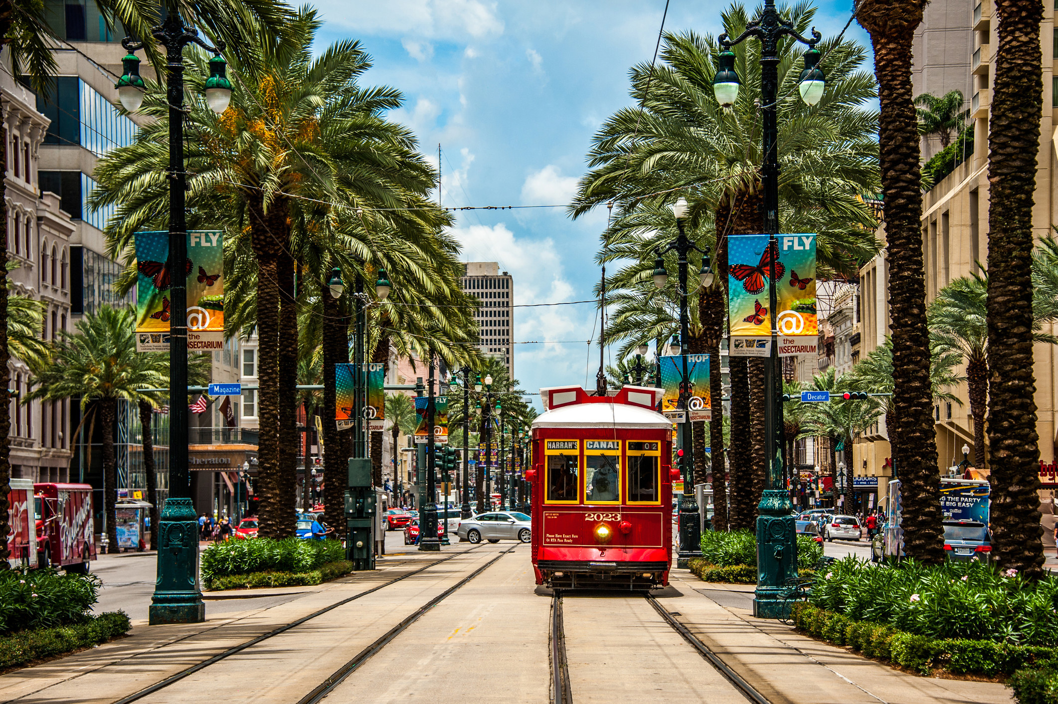 A streetcar runs down a busy street in New Orleans