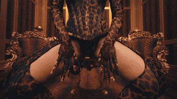 cardi flexes her thicc honkers in a leopard print corset with boob cut-outs, wearing leopard print pasties, in a leaopard-print room. 