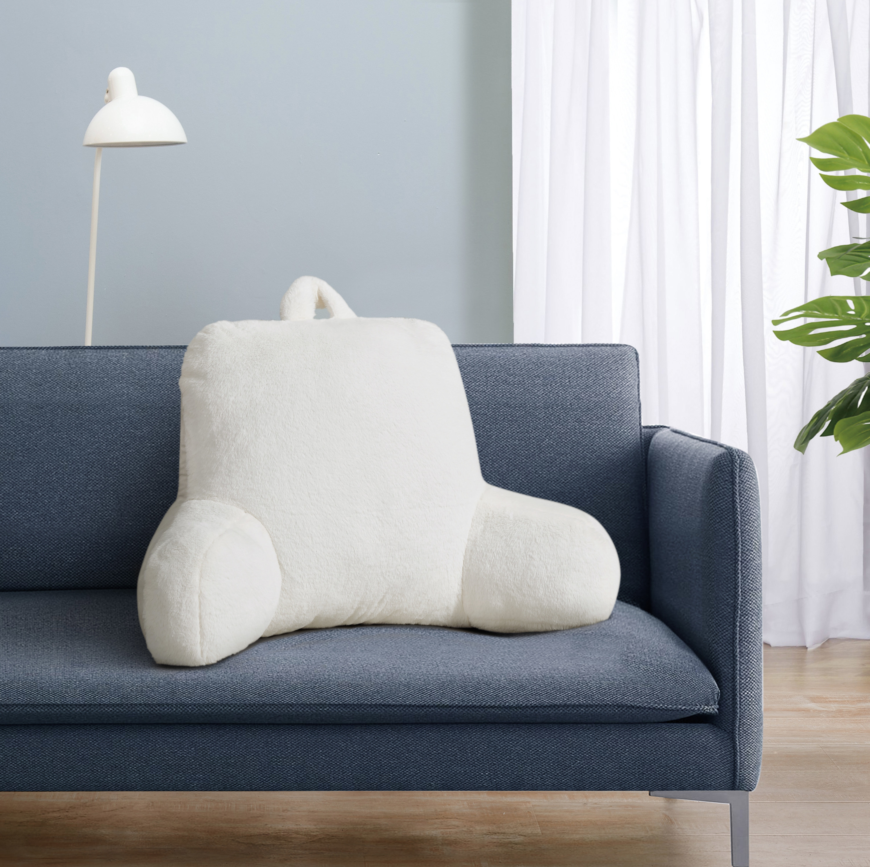 The back pillow in white on a navy couch