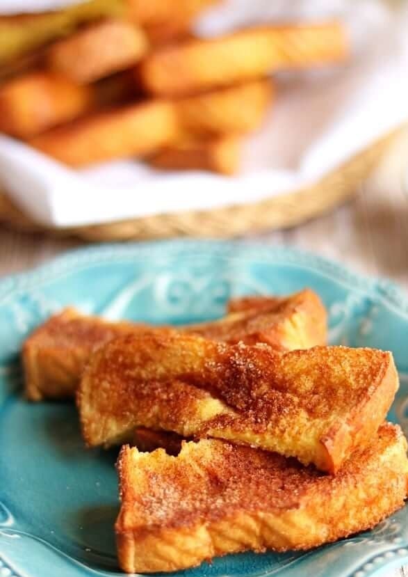 A plate of three crispy French toast sticks.